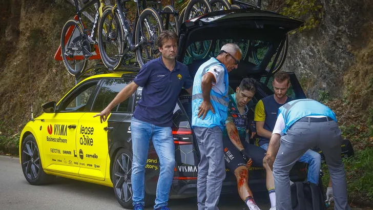 wout van aert zit op de rand van een kofferbak in de vuelta na z'n val