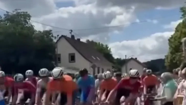Bizarre beelden uit de de LVM Saarland Trofeo, waar een bejaarde met zijn scootmobiel het peloton inrijdt en daarbij meerdere renners keihard ten val laat komen...