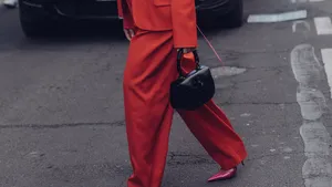 De Weekendtips van Beau Monde, week 12 2025. – Streetstyle-foto van vrouw in rood oversized broekpak.