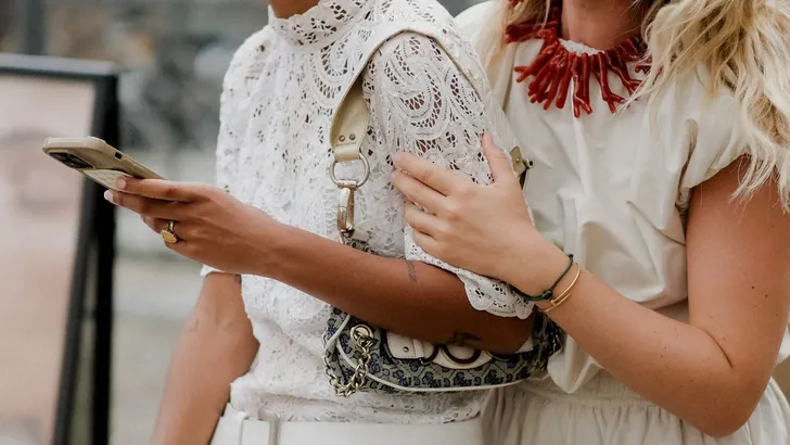 Vriendinnen in stijlvolle, zomerse kleding tijdens fashion week.