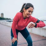 Sporty young woman checking the time after jogging.