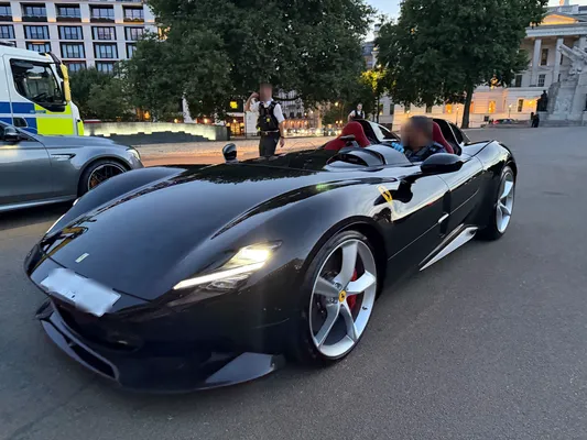 Een politieagent achter het stuur van de in beslag genomen Ferrari Monza SP2, die na de controle naar het politiedepot werd gebracht.