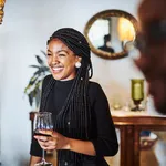 Smiling woman looking away while having wine