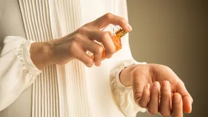 Classy look of young woman applying perfume