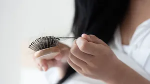 Vrouw haalt haar uit haar haarborstel.