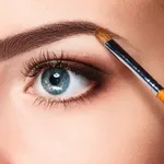 Beautiful female eyes with make-up and brush