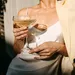 Beau Monde's tips voor het weekend. – Foto van vrouw in witte blazer met cocktail in hand.