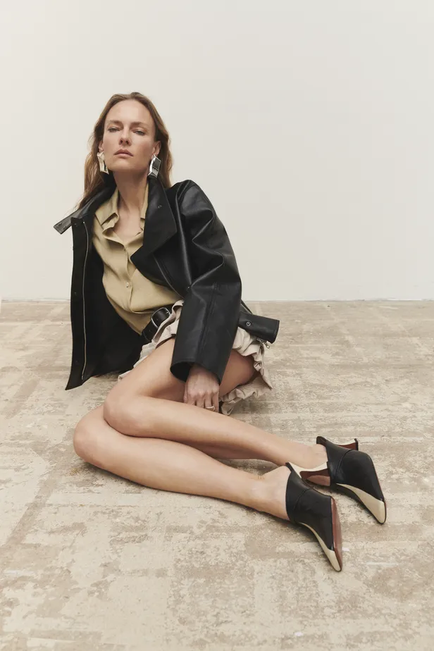 Leren jasje: Samsøe Samsøe | Overhemd: Herno, short en leren riem Sea New York| Oorbellen: Mango | Zilveren ring: Fusil Paris | Leren muiltjes: Manu Atelier