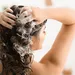 Vrouw wast haren onder de douche.