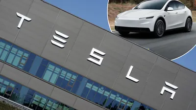 De gevel van de Tesla-fabriek met het Tesla-logo, met als inzet een witte Tesla Model Y.
