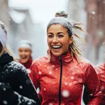 Smiling portrait of a young and diverse group of female friends jogging during the winter and snow in the city