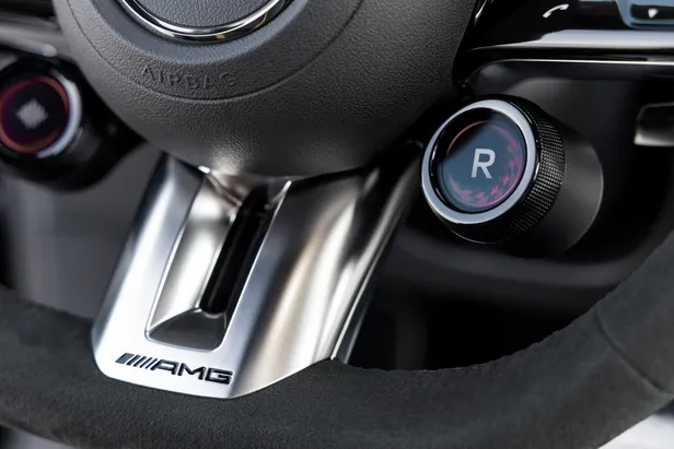 Close-up van het AMG-stuurwiel van de CLA 45 met de ronde draaiknop voor de rijprogramma's.