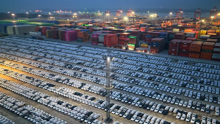 Duizenden nieuwe auto's in rijen op een kade bij een Chinese containerhaven.