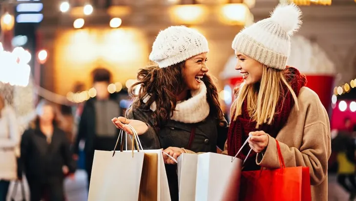 Happy women friends are shopping for presents at Christmas. People holiday sale shopping concept