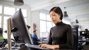 Woman busy working at her desk in open plan office