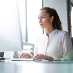 Businesswoman using computer at desk in office