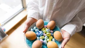 Top-down foto van vrouw met bord paaseitjes in haar handen. – Zoveel paaseitjes moet je eten om een kilo aan te komen