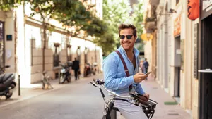 Een man op een fiets met een telefoon in zijn hand
